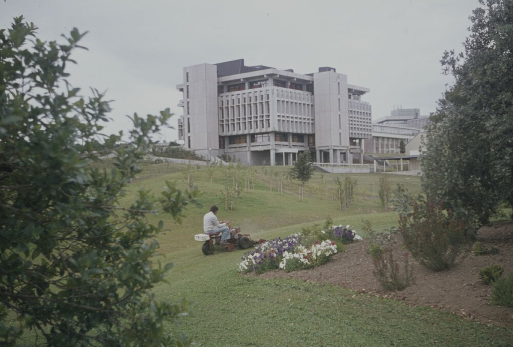 Grounds staff mowing lawn in front of Library