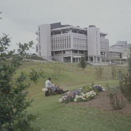 Grounds staff mowing lawn in front of Library