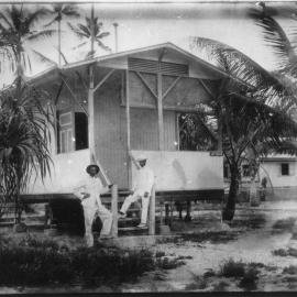 Accommodation hut Gottingen with two soldiers or sailors standing outside probably overseas